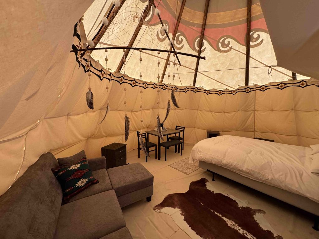 Teepee interior with sofa and bed during the Indigenous tourism Saskatchewan stay