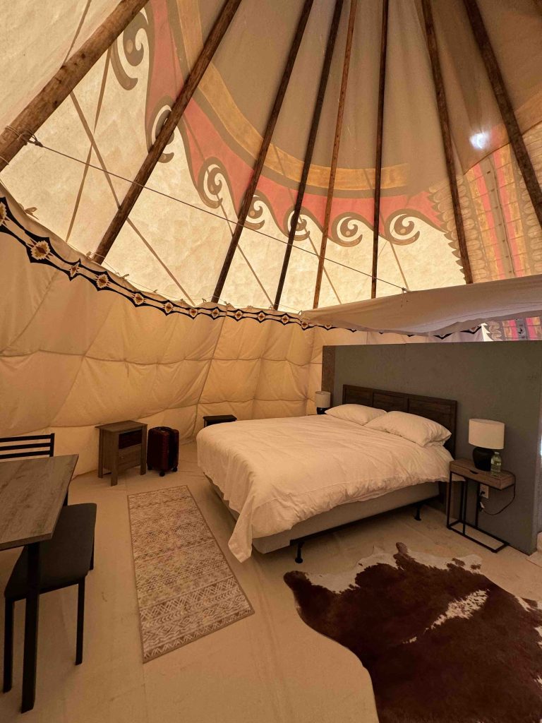 Teepee interior with bed and furniture during the Indigenous tourism Saskatchewan stay